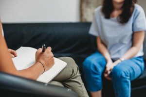 woman taking notes during therapy at a midwest detox center addiction recovery center location