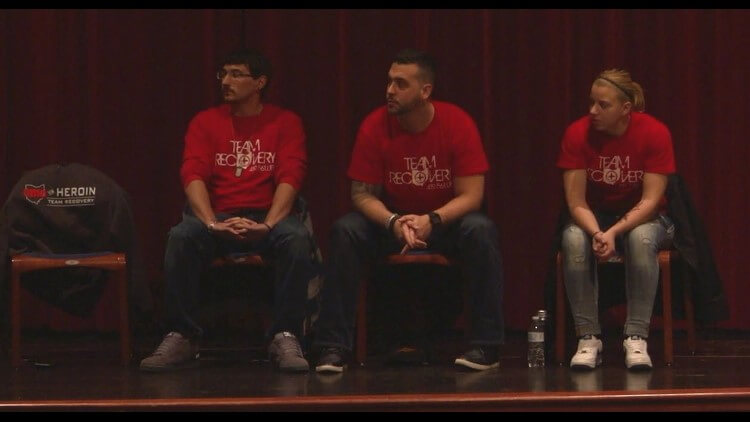 7d7f0787-cfcd-4100-9df0-0fbc0537eb37_750x422-1 three people with team recovery shirts on sitting in a row