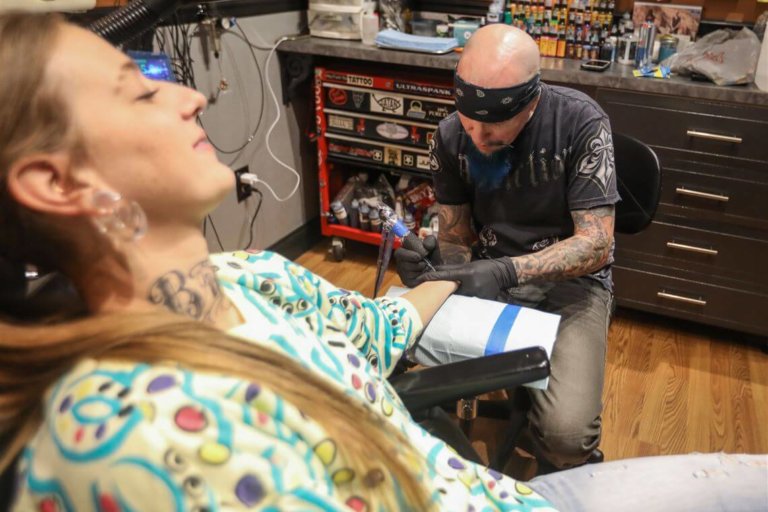 a woman getting tattooed