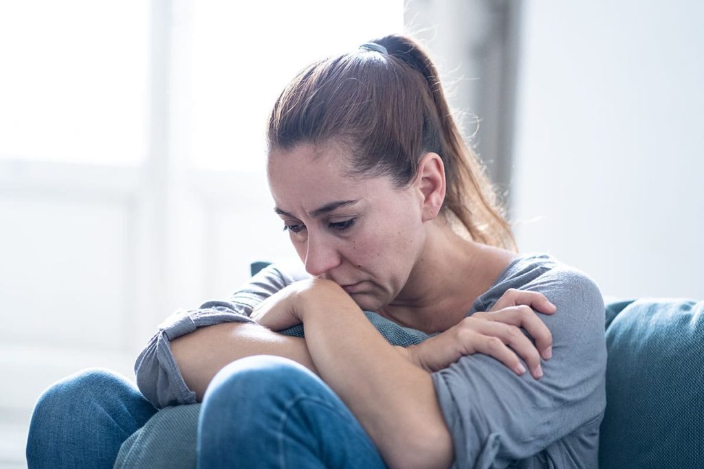 a woman sitting on her house thinking about drug overdose symptoms