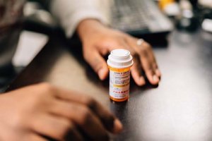 person with a prescription bottle on desk needing the Opioid detox center in Ohio