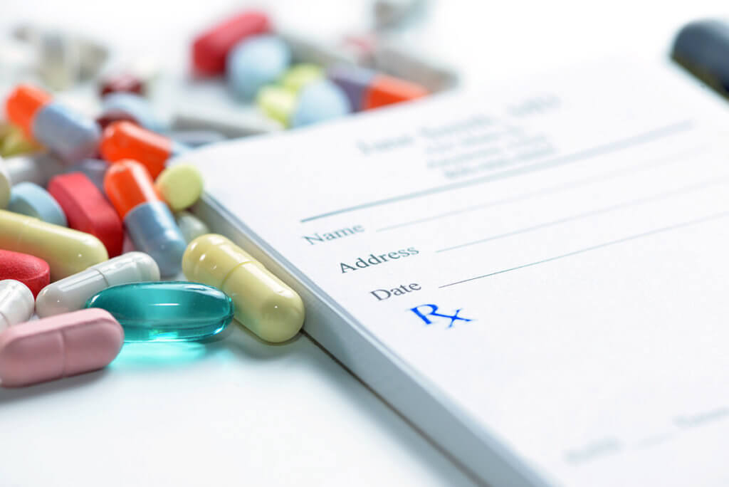 pills and prescription pad showing the Most Abused Prescription Drugs