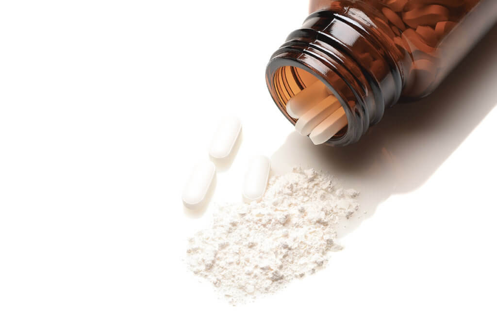 crushed and whole pills showing the Opioid Crisis