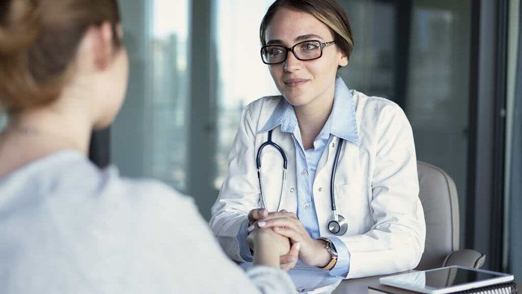 doctor holding patient's hand as she Stops Addictive Behaviors