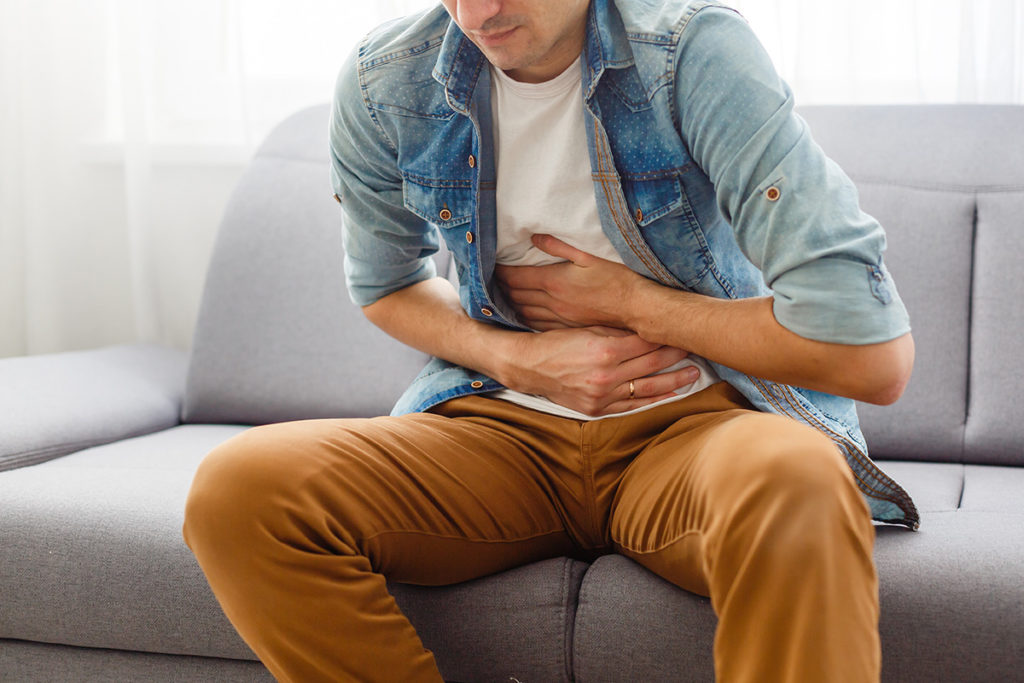 man holding stomach from the effects of cocaine