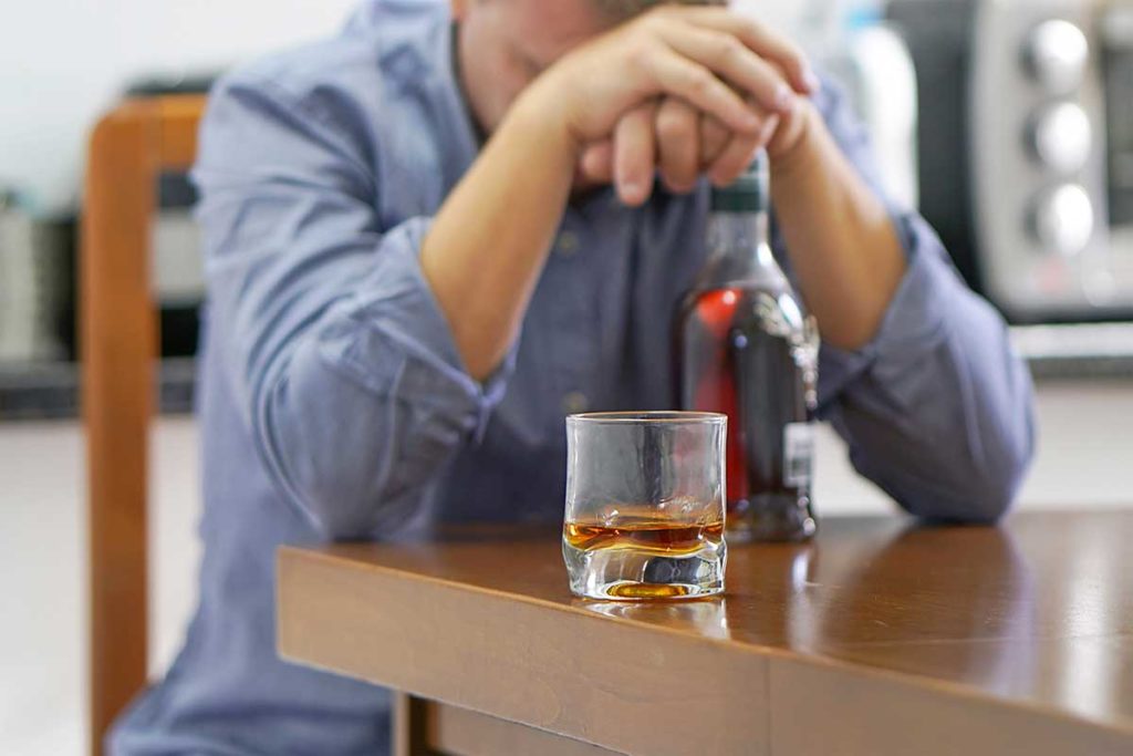 person with liquor bottle needing help for alcoholism