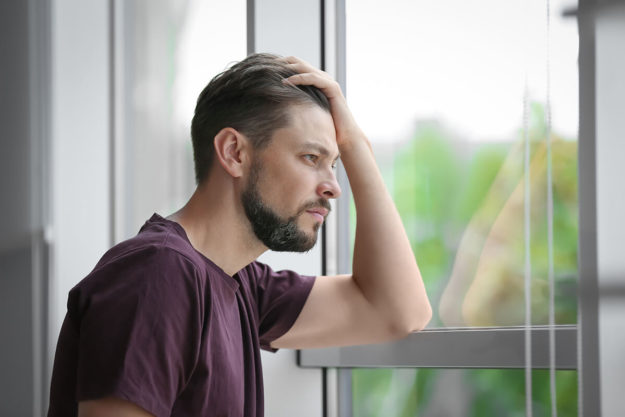 4-Differences-Between-CBT-vs. DBT man looking out window wondering about cbt vs dbt