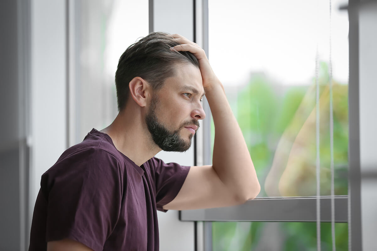 man looking out window wondering about cbt vs dbt