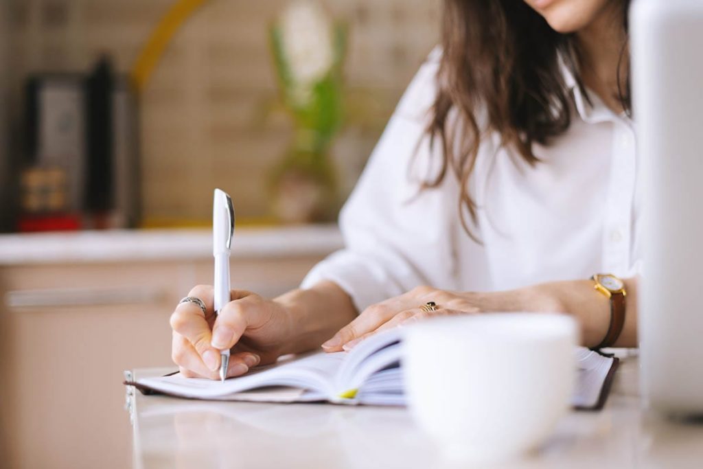 woman writing list of things to do instead of drinking