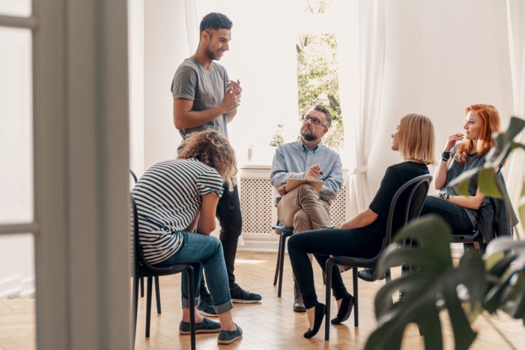 a group talking about 3 common addiction triggers and how to avoid them