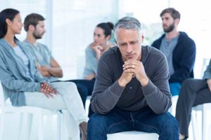 man sitting and thinking in group at adderall detox center