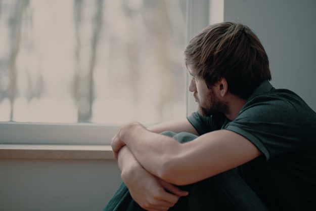 Is Marijuana Addictive_ a man looking out a window wondering is marijuana addictive