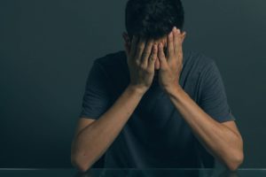 a man with his face in his hands thinking about fentanyl withdrawal symptoms
